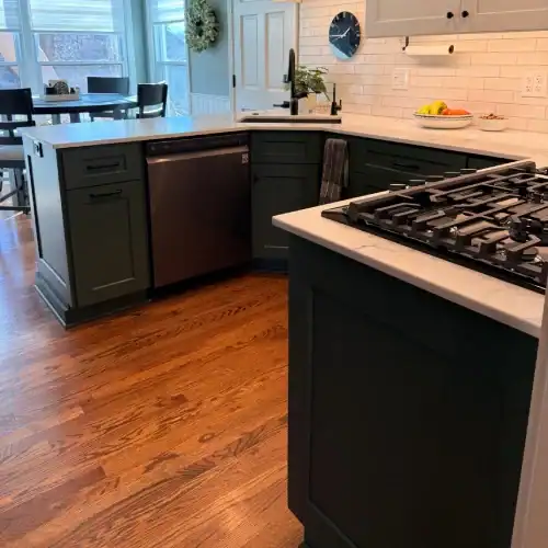 Compact Kitchen Island With Gas Cooktop And Quartz Counters By Stag Homes In Overland Park, Ks Compact kitchen remodel Overland Park featuring a dark island with gas cooktop, white quartz counters, and subway tile backsplash by Stag Homes in Overland Park, KS