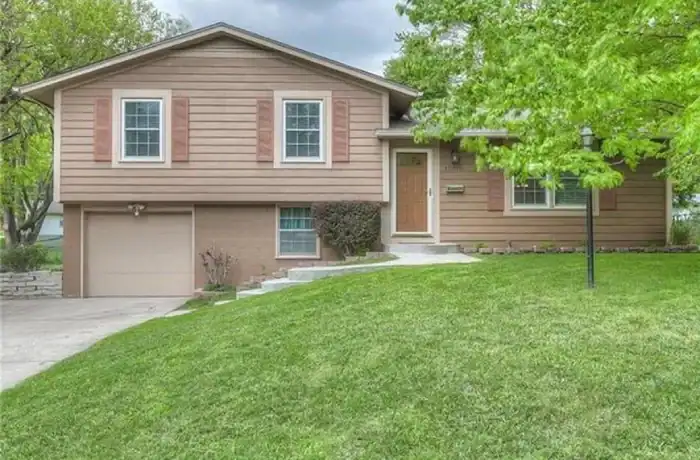 Split-level home with updated siding, trimmed windows, and fresh roof enhancing curb appeal by Stag Homes in Kansas City