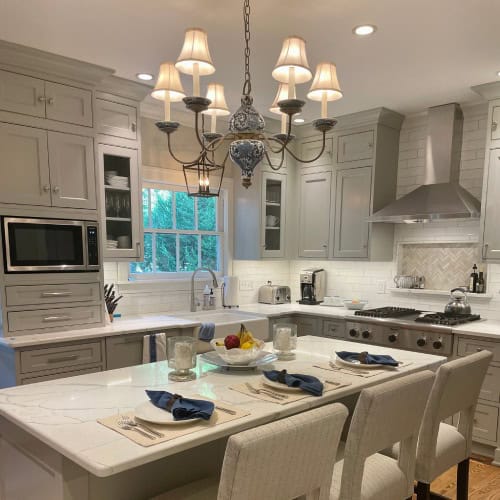 Full Kitchen Remodel With Island Seating And Gray Cabinets By Stag Homes In Kansas City Finished kitchen remodel with large island, gray cabinets, stainless hood, and lighting by kitchen remodeling companies near me by Stag Homes in Kansas City