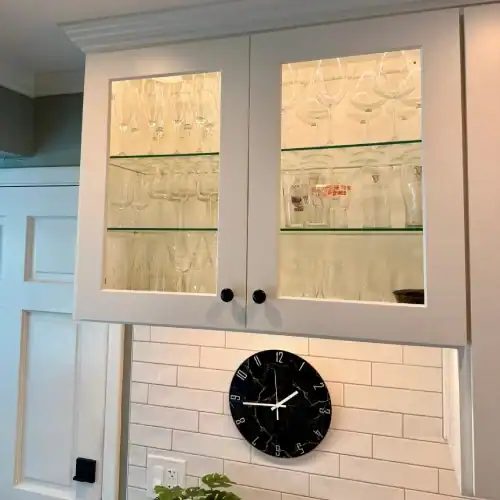 Glass Front Display Cabinets With Under Cabinet Lighting By Stag Homes In Overland Park, Ks Kitchen remodel Overland Park showcasing glass-front display cabinets, interior lighting, and white subway tile backsplash by Stag Homes in Overland Park, KS