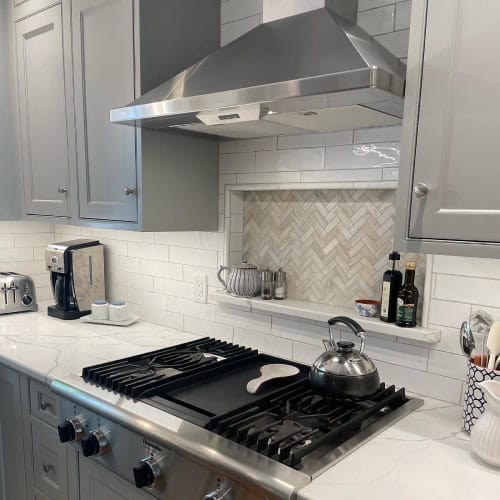 Kitchen Remodel Details With Gas Range And Herringbone Backsplash By Stag Homes In Kansas City Gas range, stainless hood, and herringbone tile backsplash from kitchen remodeling companies near me by Stag Homes in Kansas City